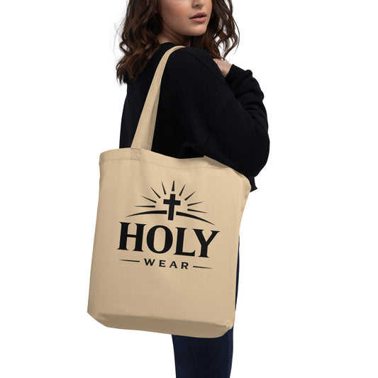Natural cotton Christian faith eco tote bag featuring the Holy Wear logo worn by a model