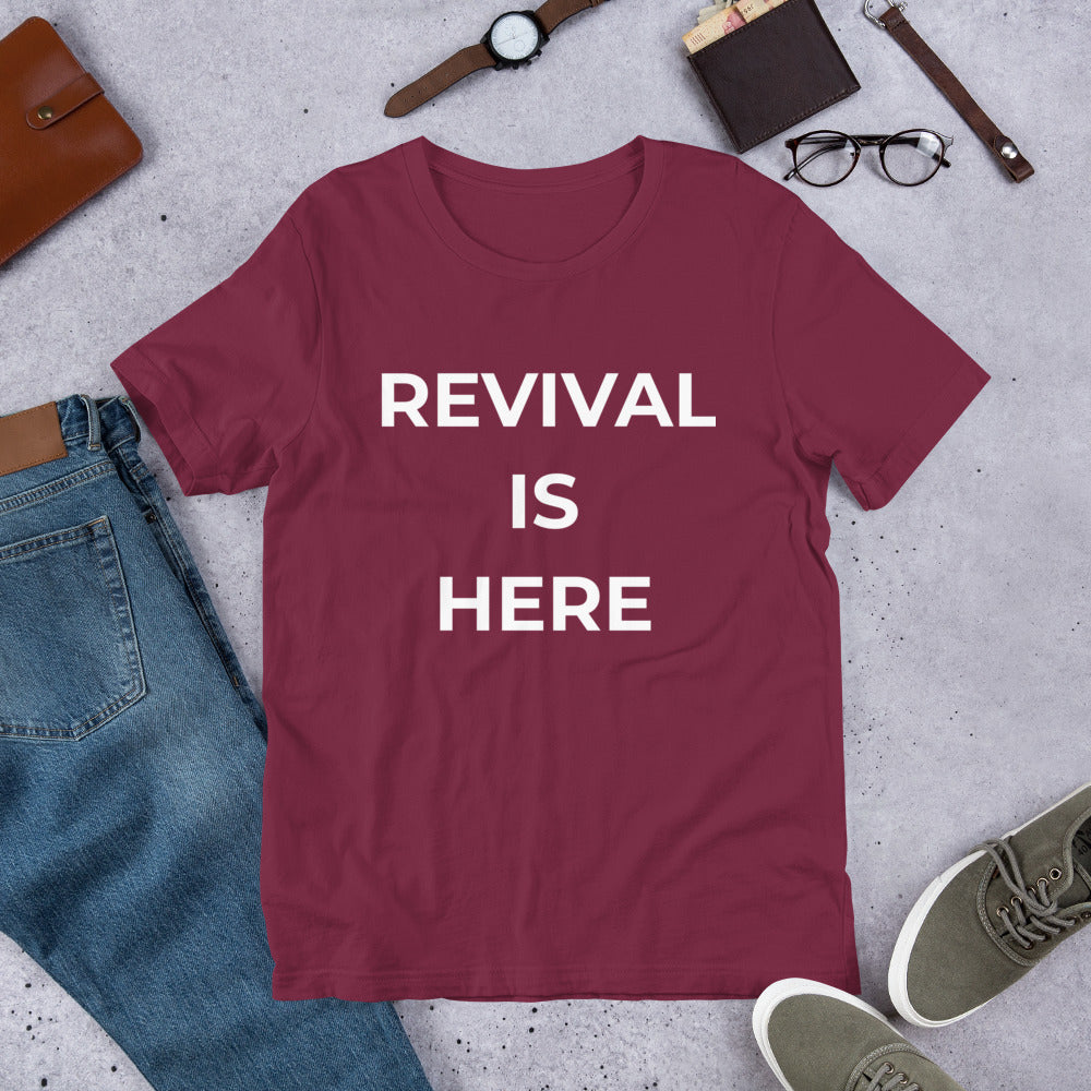 Flat lay of black heather unisex Christian revival t-shirt with “Revival Is Here” text design
