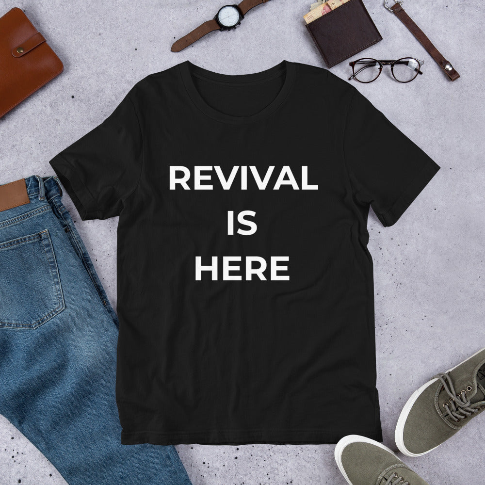 Flat lay of black heather unisex Christian revival t-shirt with “Revival Is Here” text design

