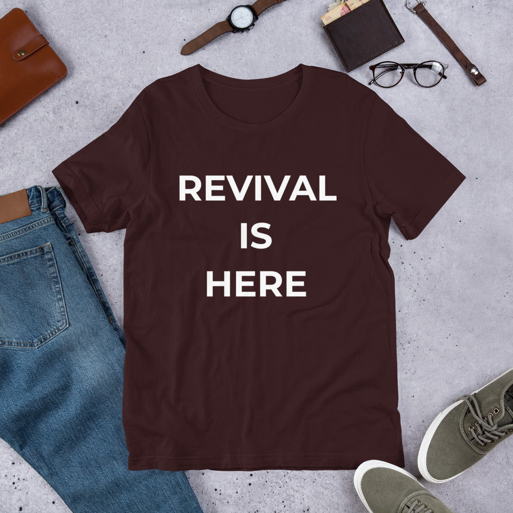 Flat lay of black heather unisex Christian revival t-shirt with “Revival Is Here” text design
