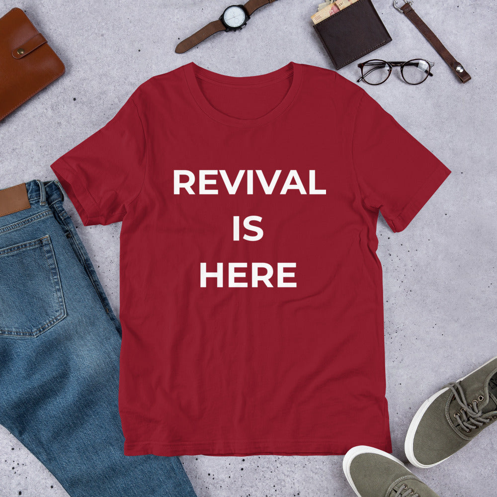 Flat lay of black heather unisex Christian revival t-shirt with “Revival Is Here” text design
