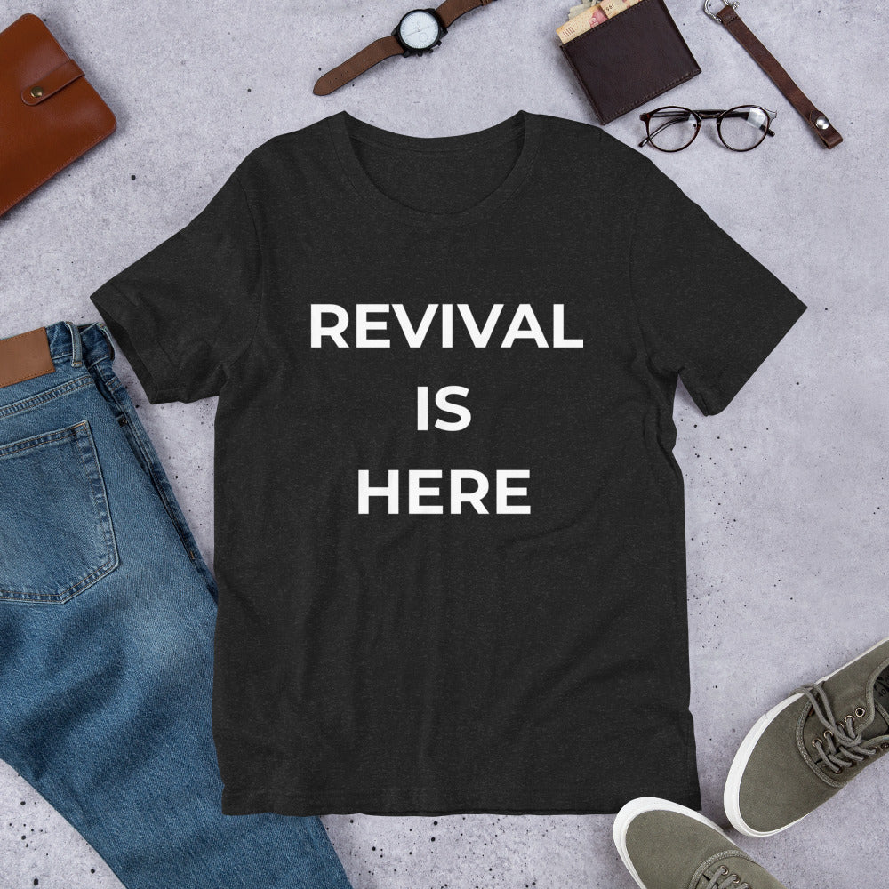 Flat lay of black heather unisex Christian revival t-shirt with “Revival Is Here” text design
